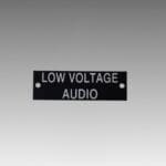 Black sign displaying "Low Voltage Audio" text.